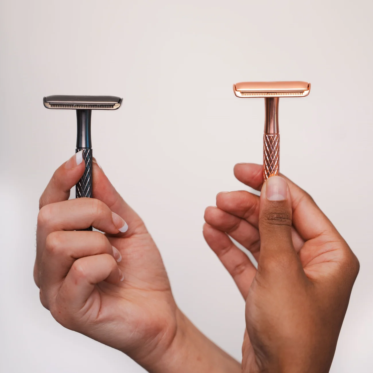 De roze en zwarte Glowlie safety razor in de hand